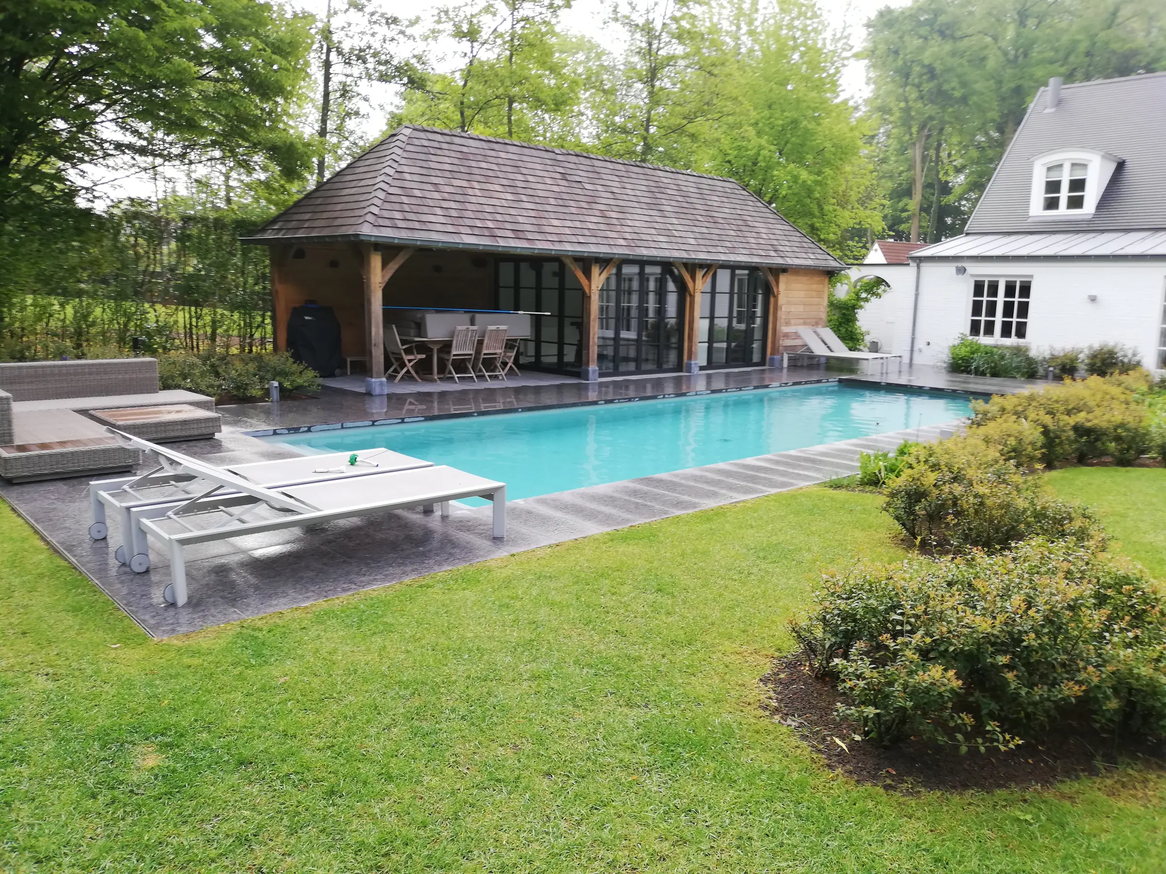 Zwembad in Overijse, met houten poolhouse en natuurstenen terras