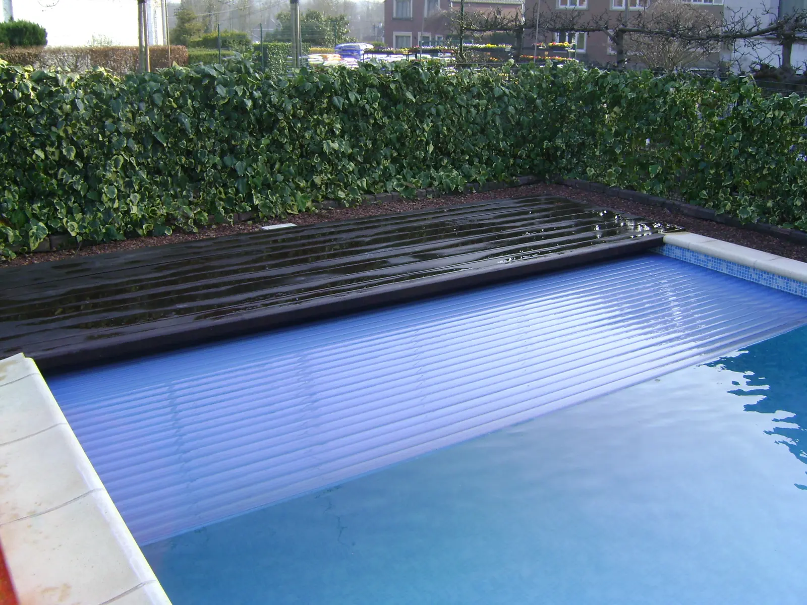 Zwembad met houten terras en haag (foto 2 van 4)
