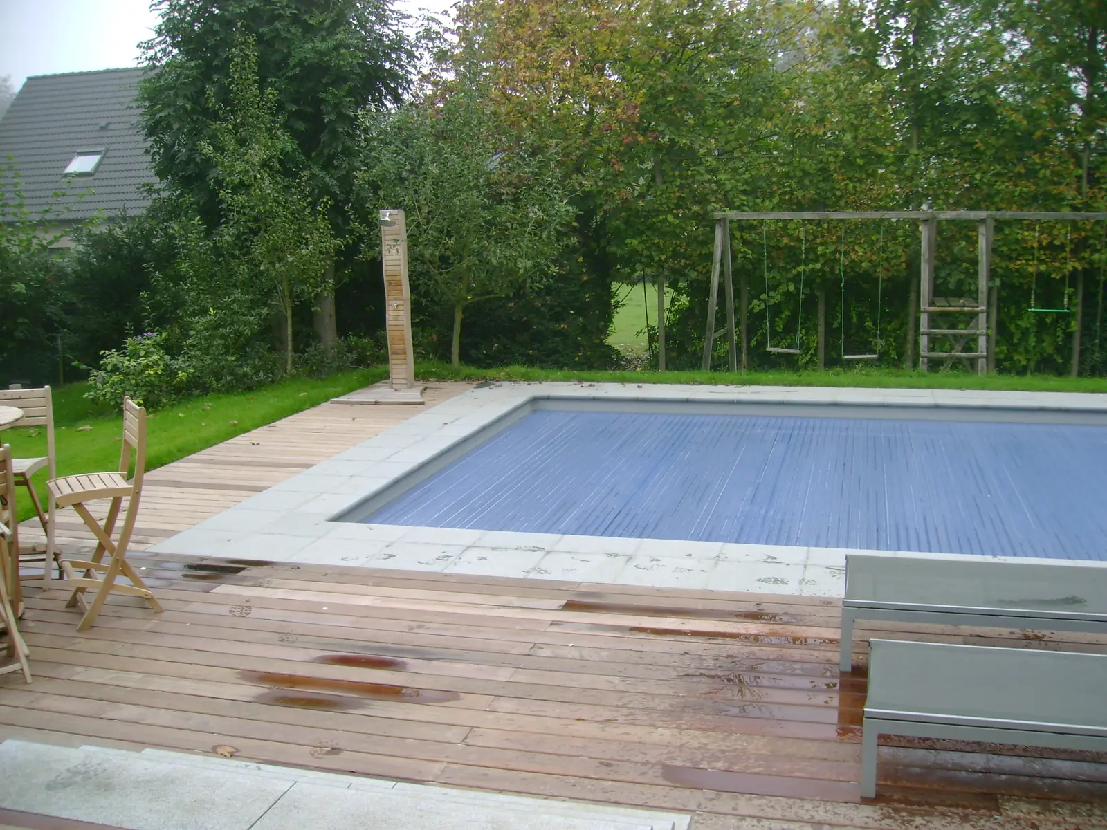 Zwembad met rolluik en houten terras (foto 1 van 4)