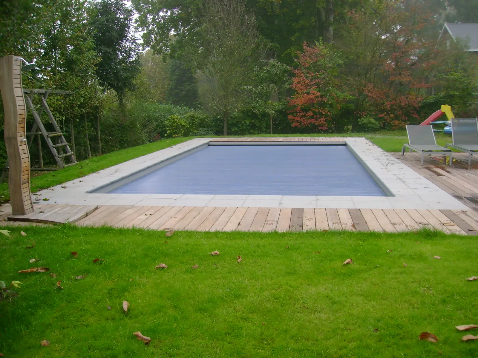 Zwembad met rolluik en houten terras (foto 4 van 4)