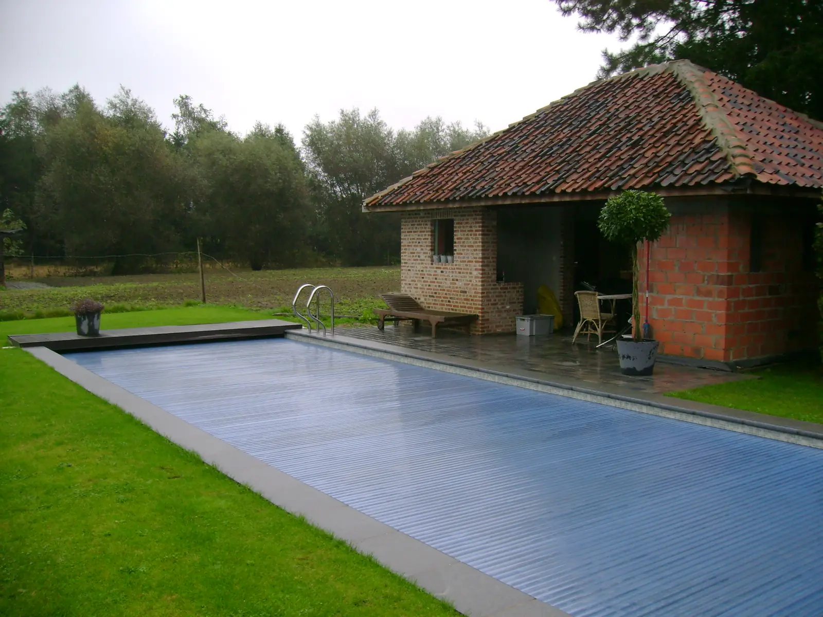 Zwembad met rolluik bij een tuinhuis (foto 1 van 3)