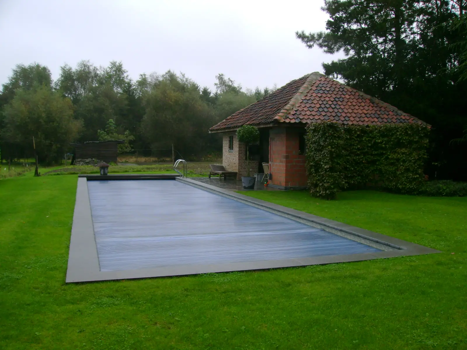 Zwembad met rolluik bij een tuinhuis (foto 2 van 3)